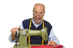 man wearing white button-up dress shirt with blue shirt and black-framed eyeglasses holding green sewing machine